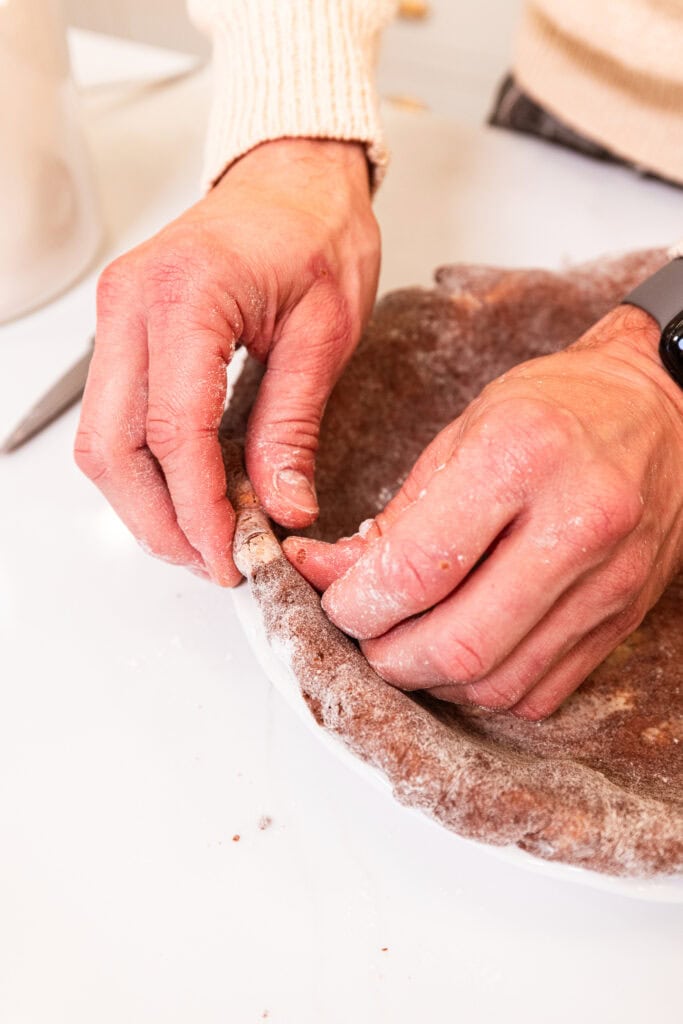 Rolling the edge of the pie crust under itself in the pie dish.