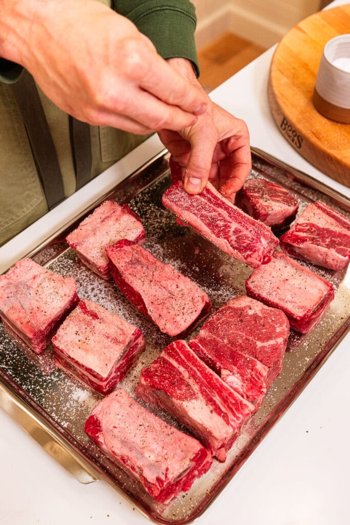 Seasoning the sides of short ribs.