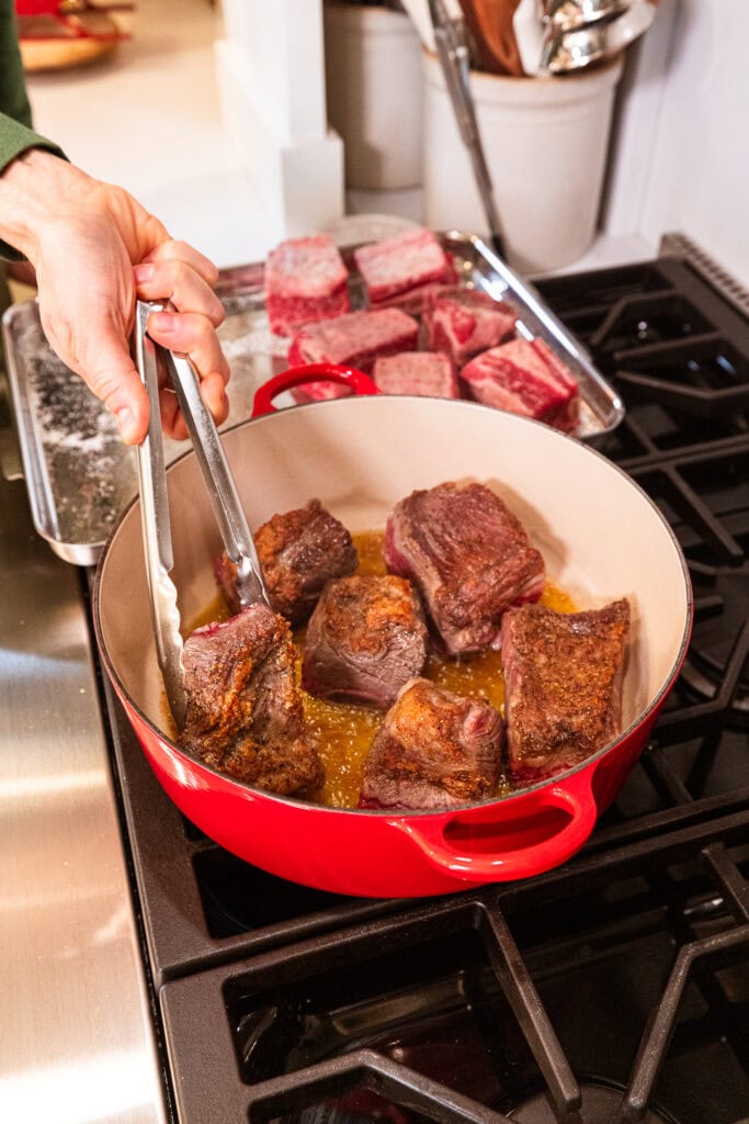 Flipping short ribs to cook each side.