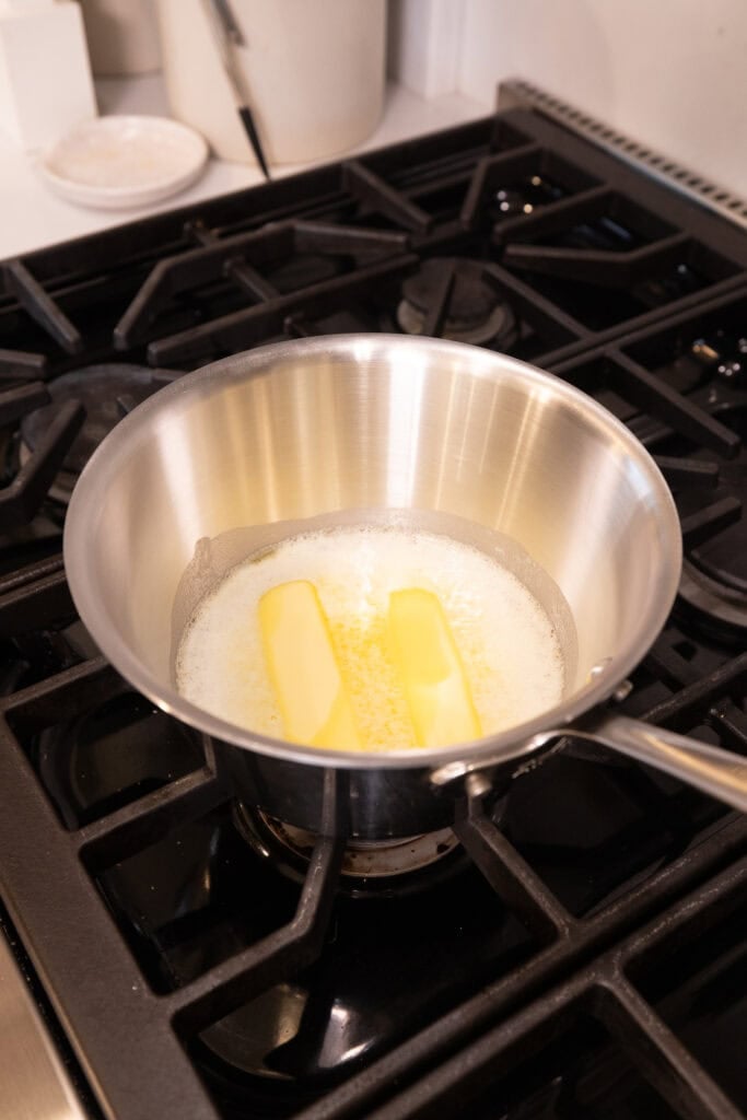Butter melts in a saucepan on a stove to create brown butter.