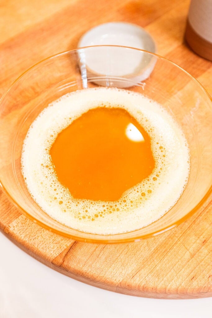 Brown butter begins to cool in a glass bowl.