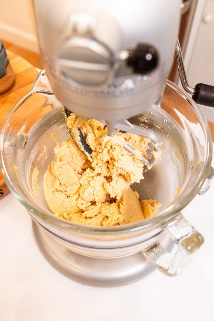 Cookie dough in a stand mixer after being mixed.