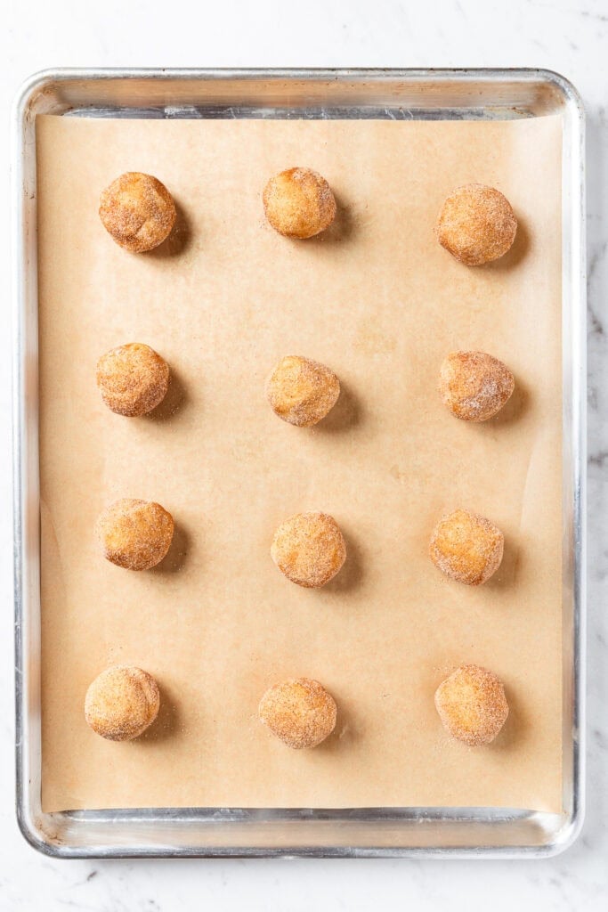 A baking sheet with individual balls of cookie dough prior to baking.
