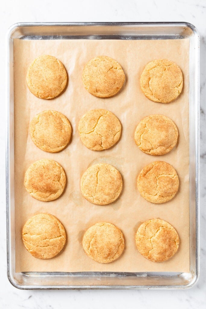A sheet of snickerdoodle cookies after coming out of the oven.