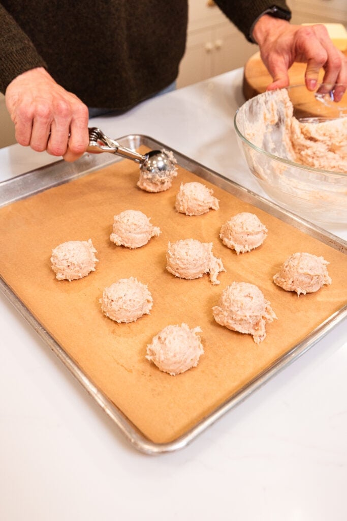 Forming meatballs on a baking sheet to roast.