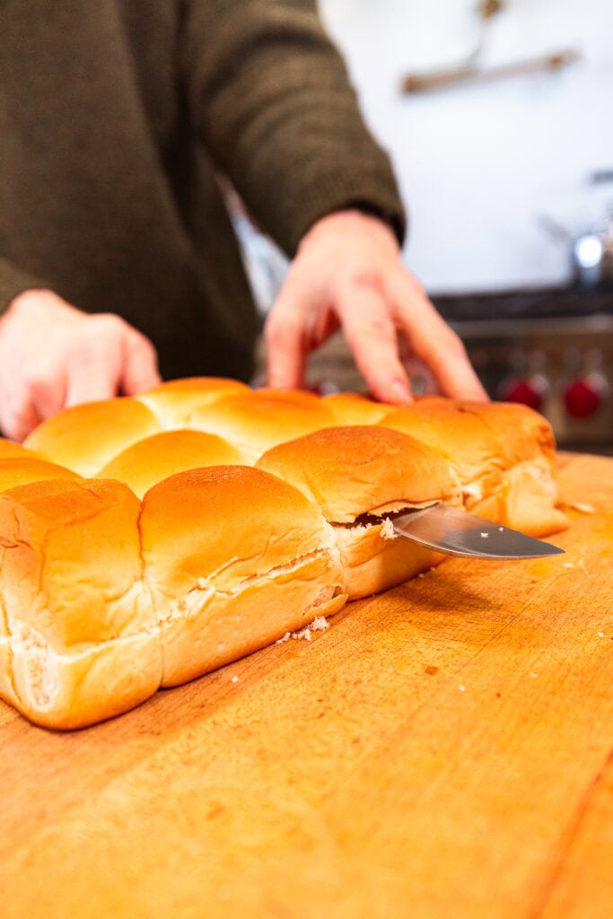 Slicing through a sheet of sweet rolls.