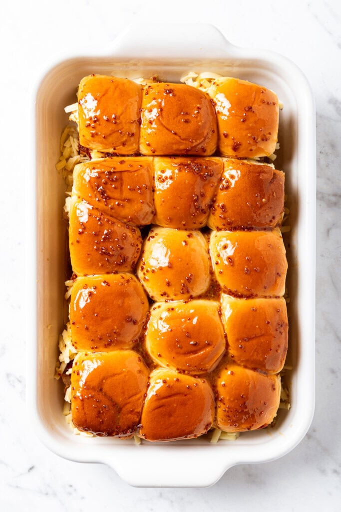 Holiday sliders in a baking dish prior to roasting.