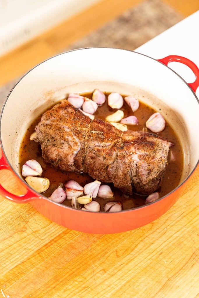 Browned pork roast in a pot prior to roasting.