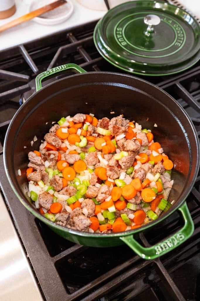 Vegetables and sausage cooking in a Dutch oven
