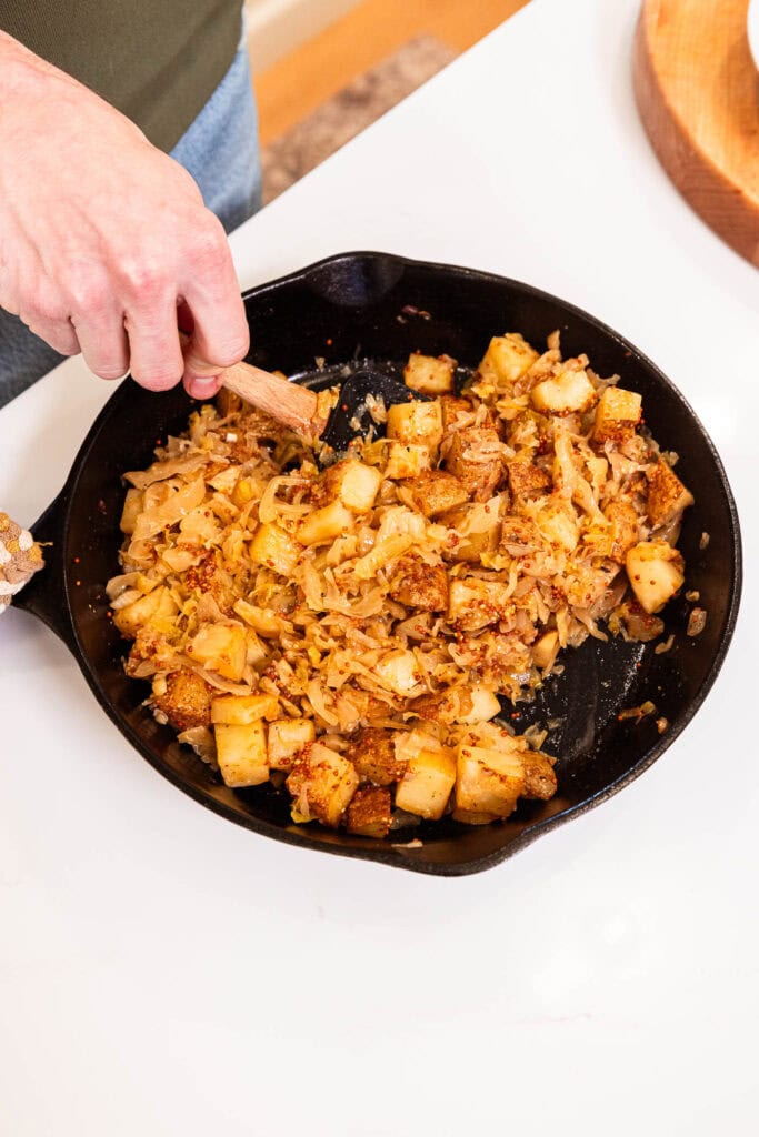 Potatoes and onions in a skillet after roasting.