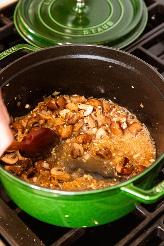 Mushrooms and onion cook with butter and white wine.