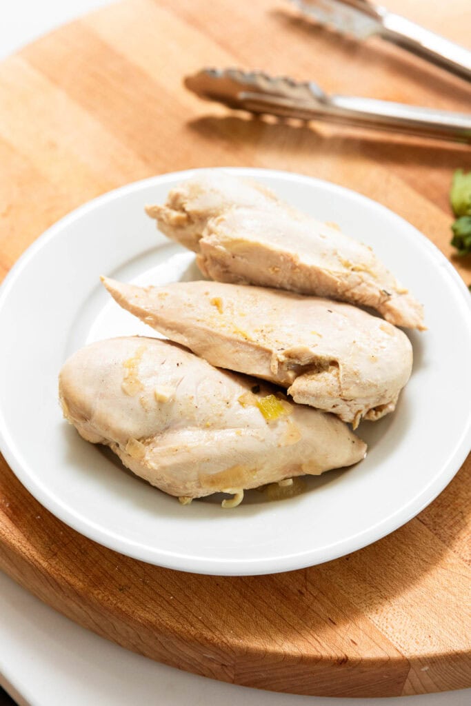 Chicken breast on a plate after being poached.
