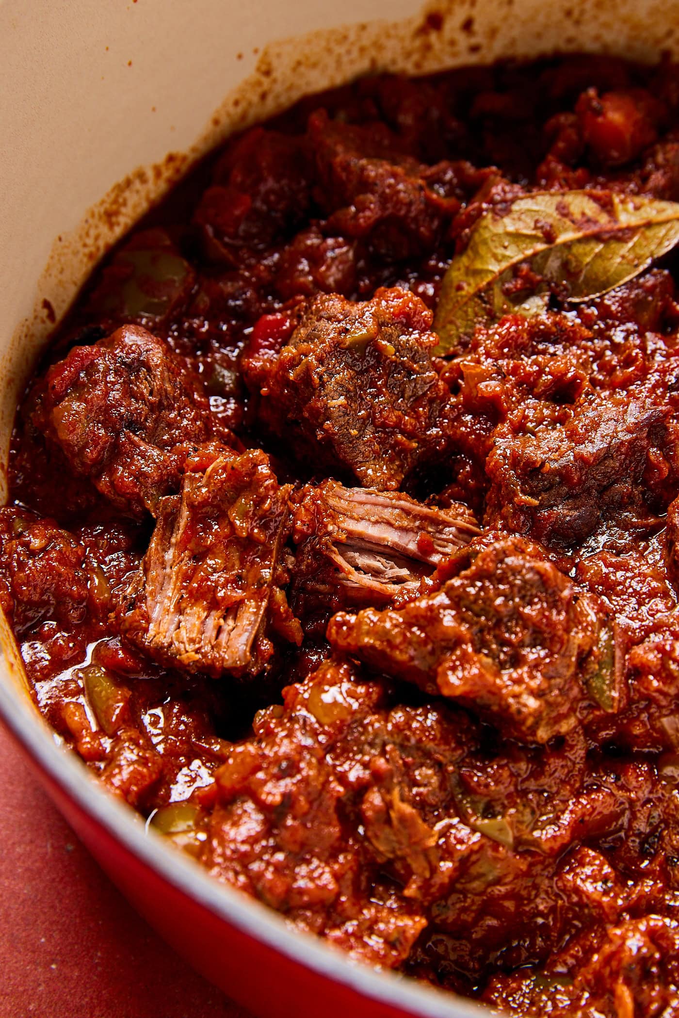 Pieces of meat in a pot full of chili con carne.