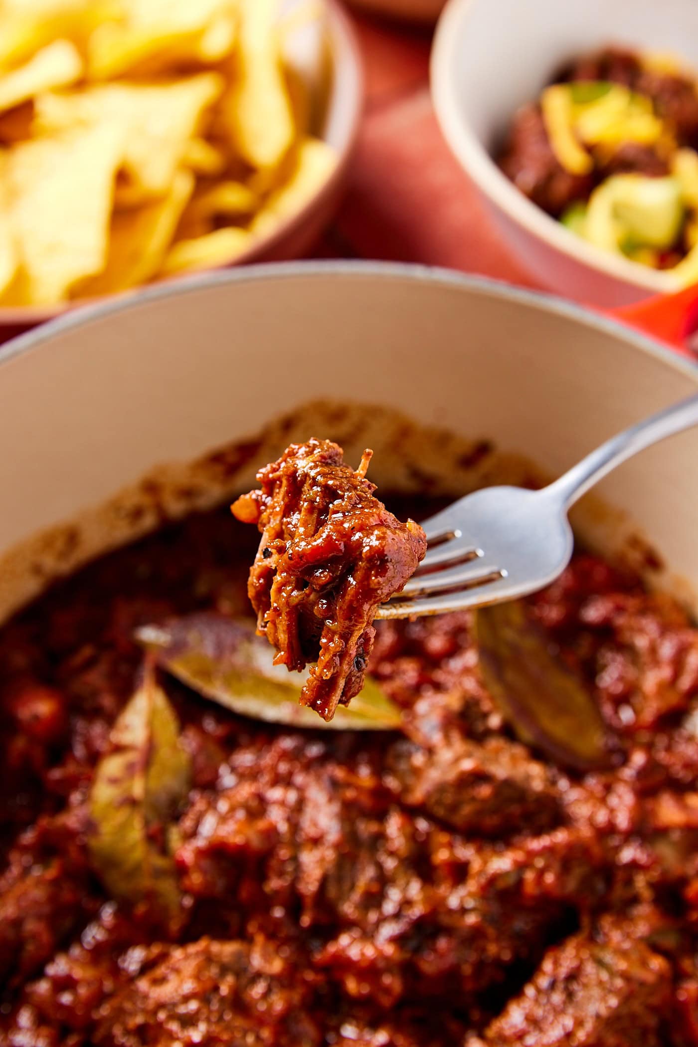 A fork showing a piece of meat from chili con carne.
