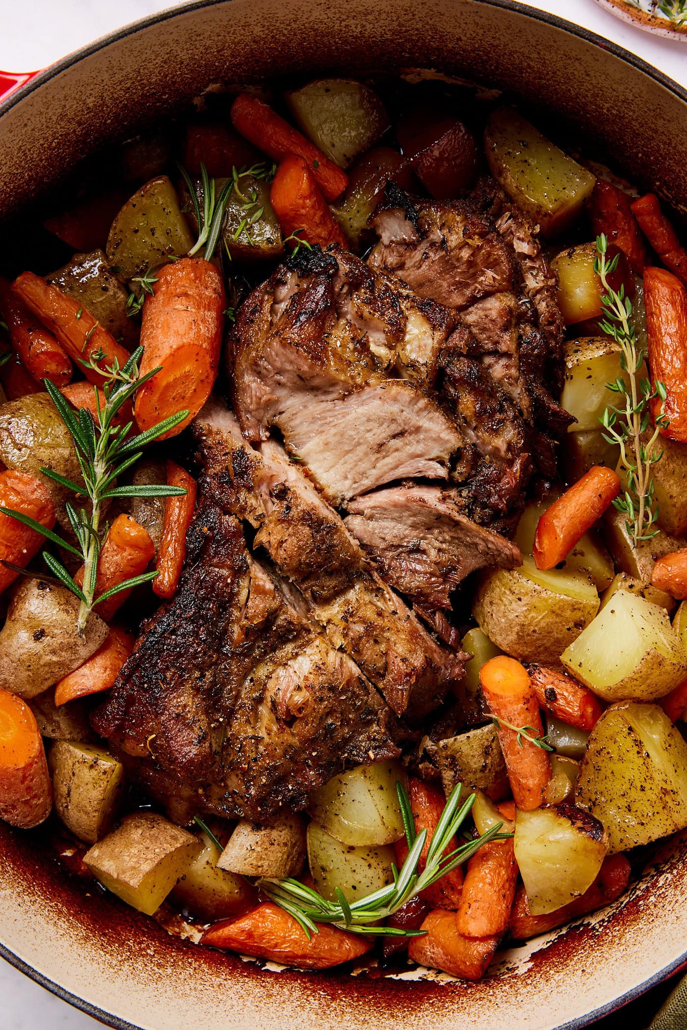 Sliced pork pot roast surrounded by veggies.