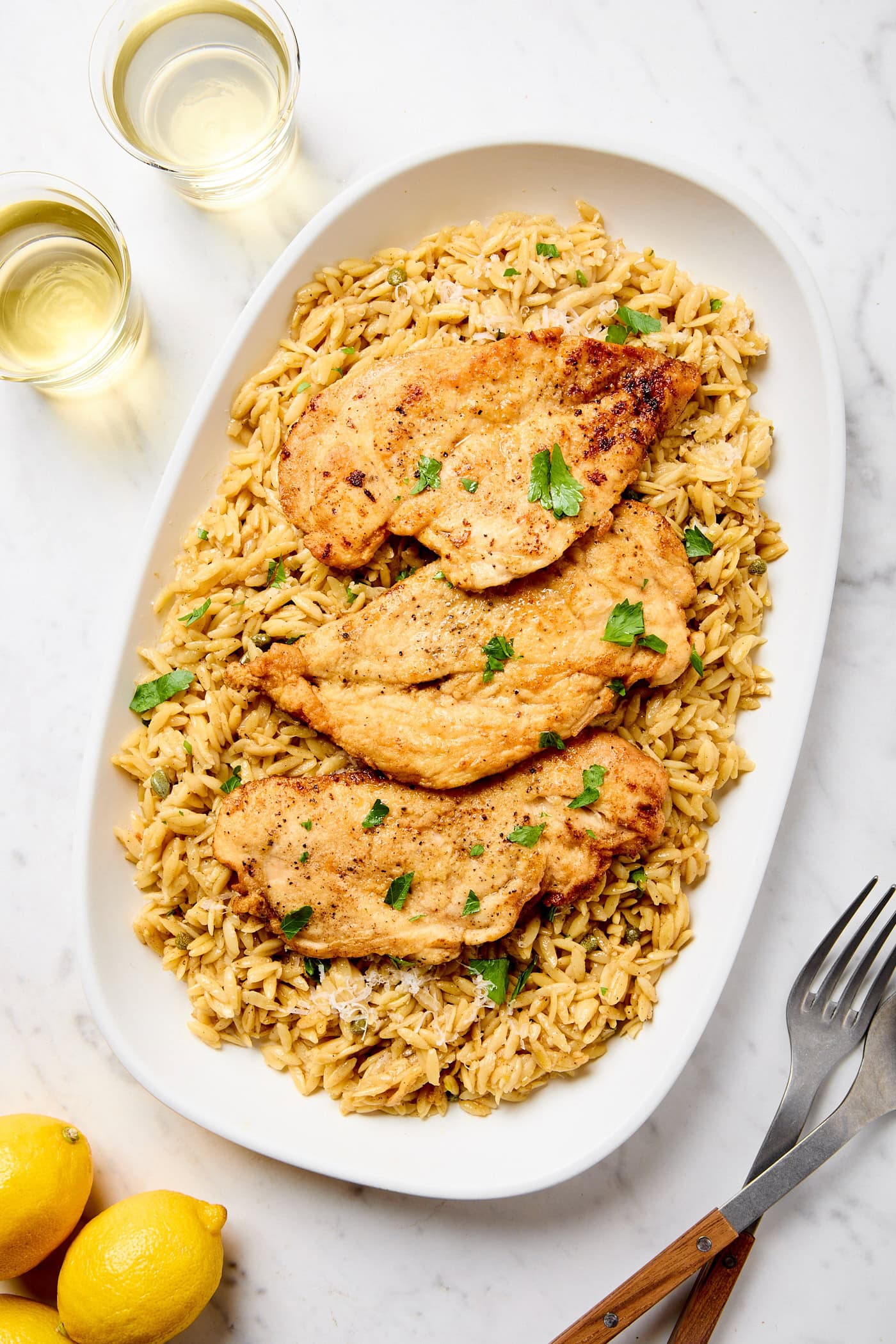 Orzo and chicken cutlets on a platter.