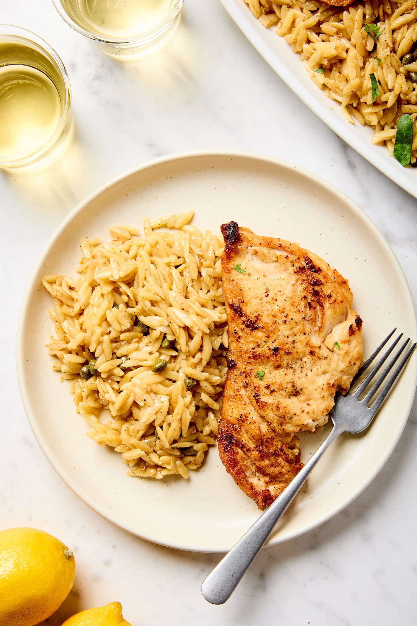 Chicken Piccata with orzo on a plate.