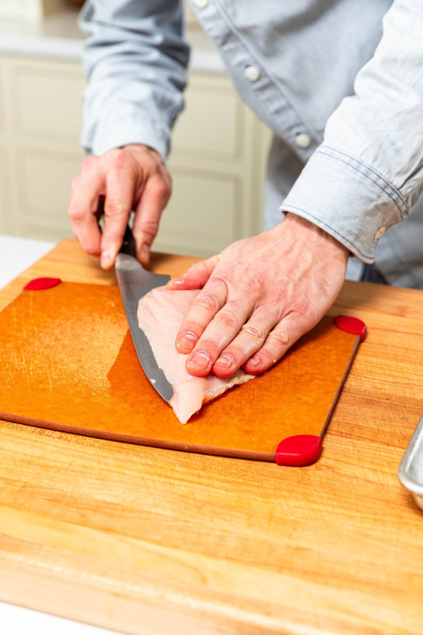 Slicing a chicken breast into cutlets.