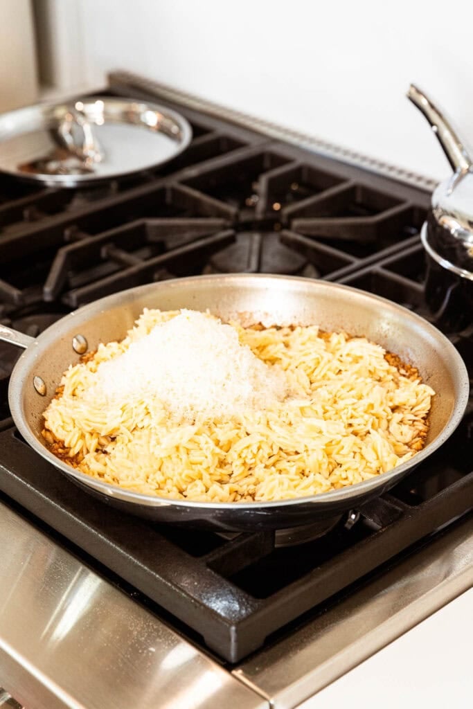 Parmesan cheese melting into orzo.