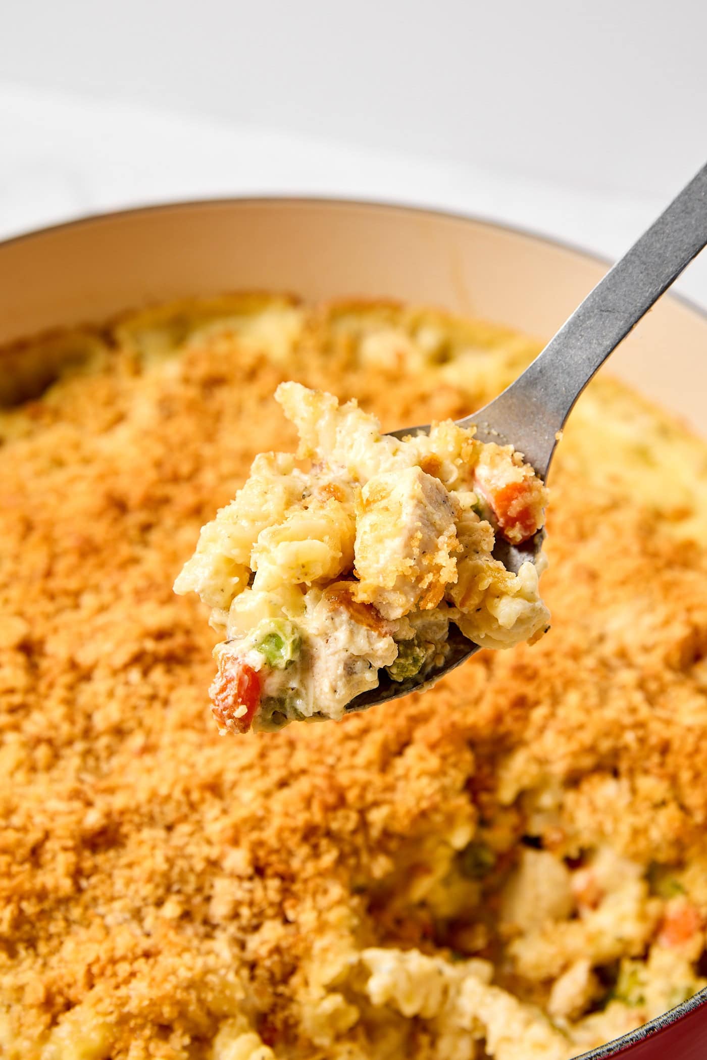 Scooping out chicken pot pie casserole from a dish.