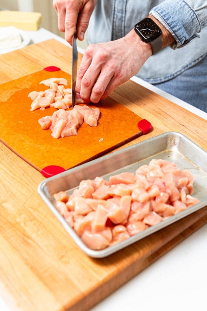 Dicing chicken into bite sized pieces.