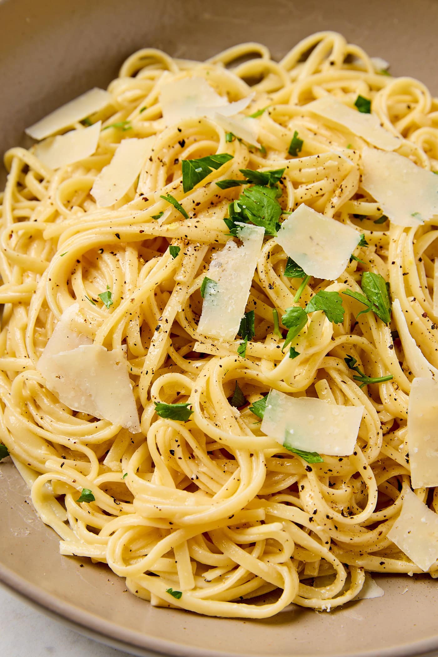 Noodles with lemon butter sauce and black pepper on a plate.