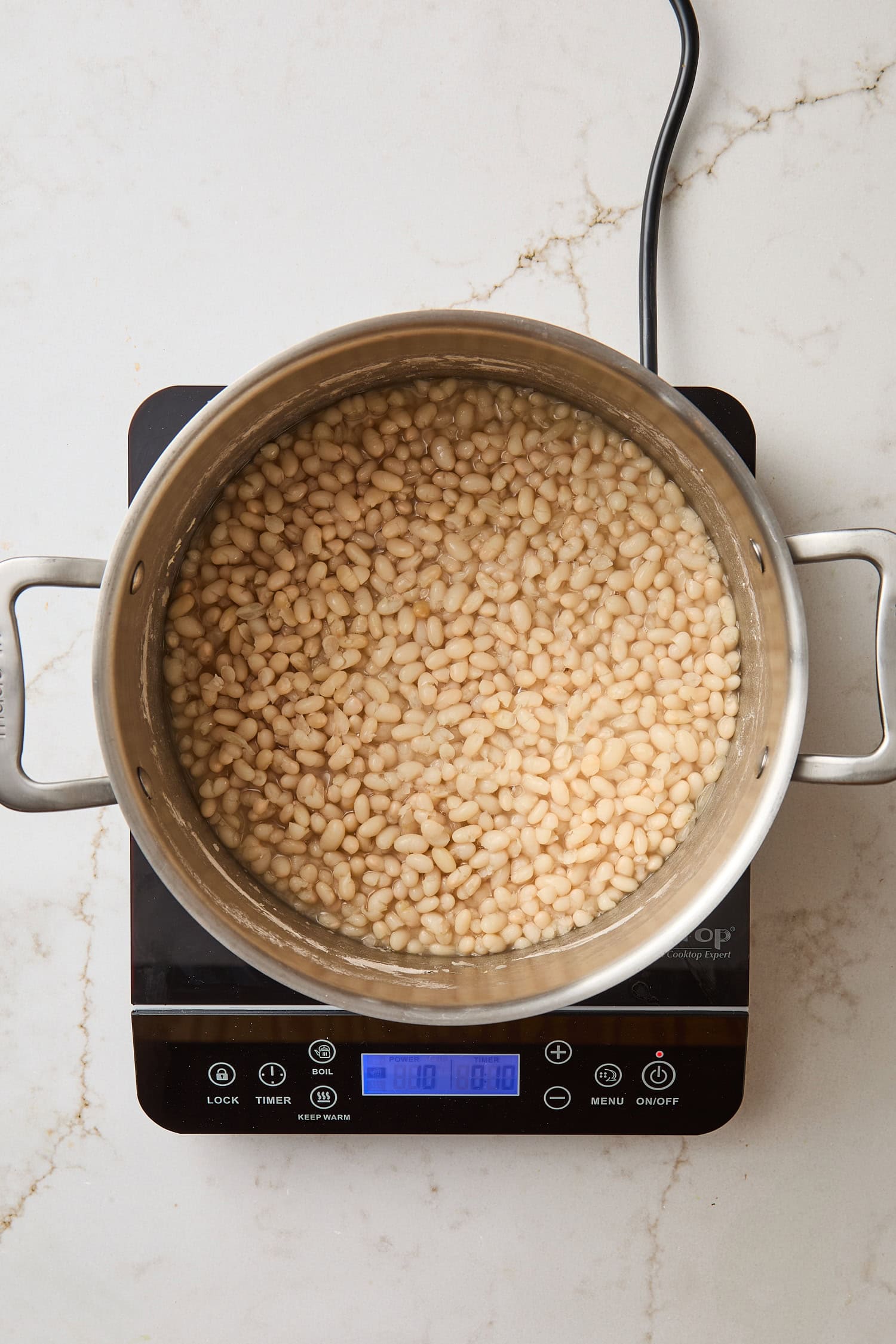 Saucepan filled with cooking dried beans.