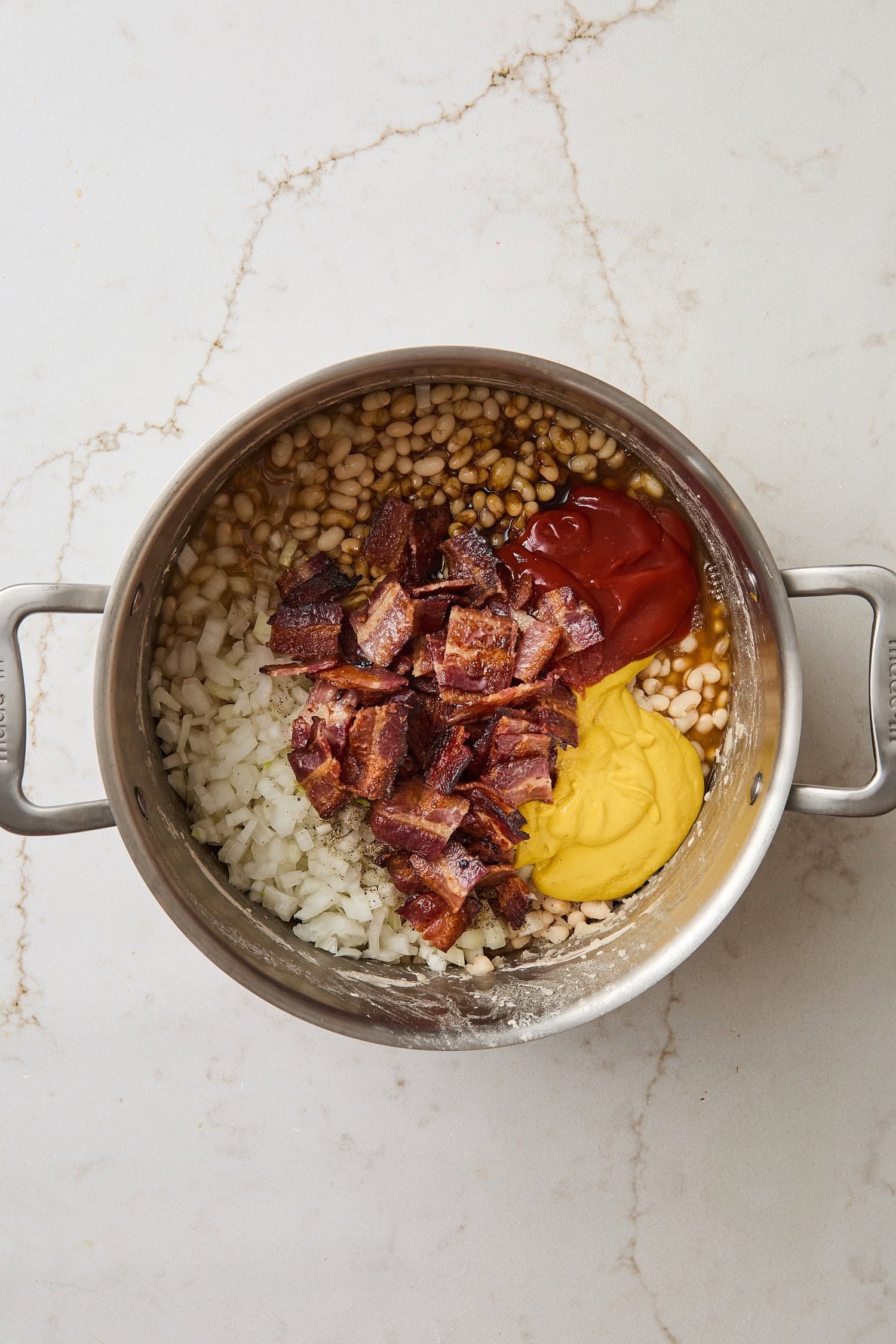 Saucepan with all ingredients needed for homemade baked beans.