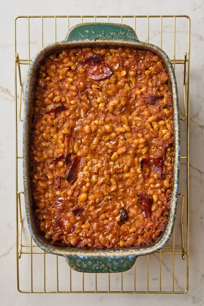 Cooked baked beans sitting in casserole dish cooling after coming out of the oven.