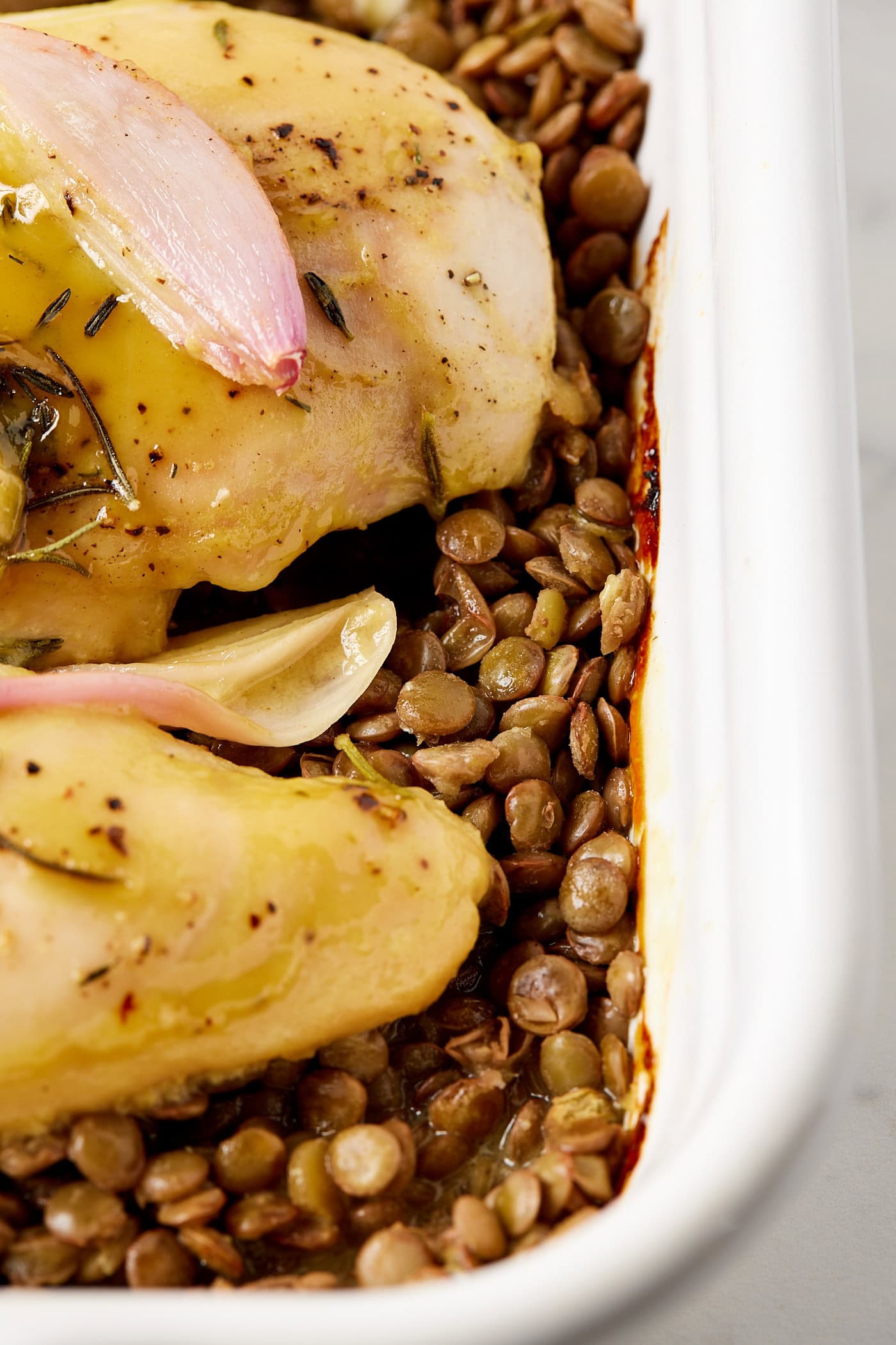 Lentils sitting under honey mustard chicken breasts.