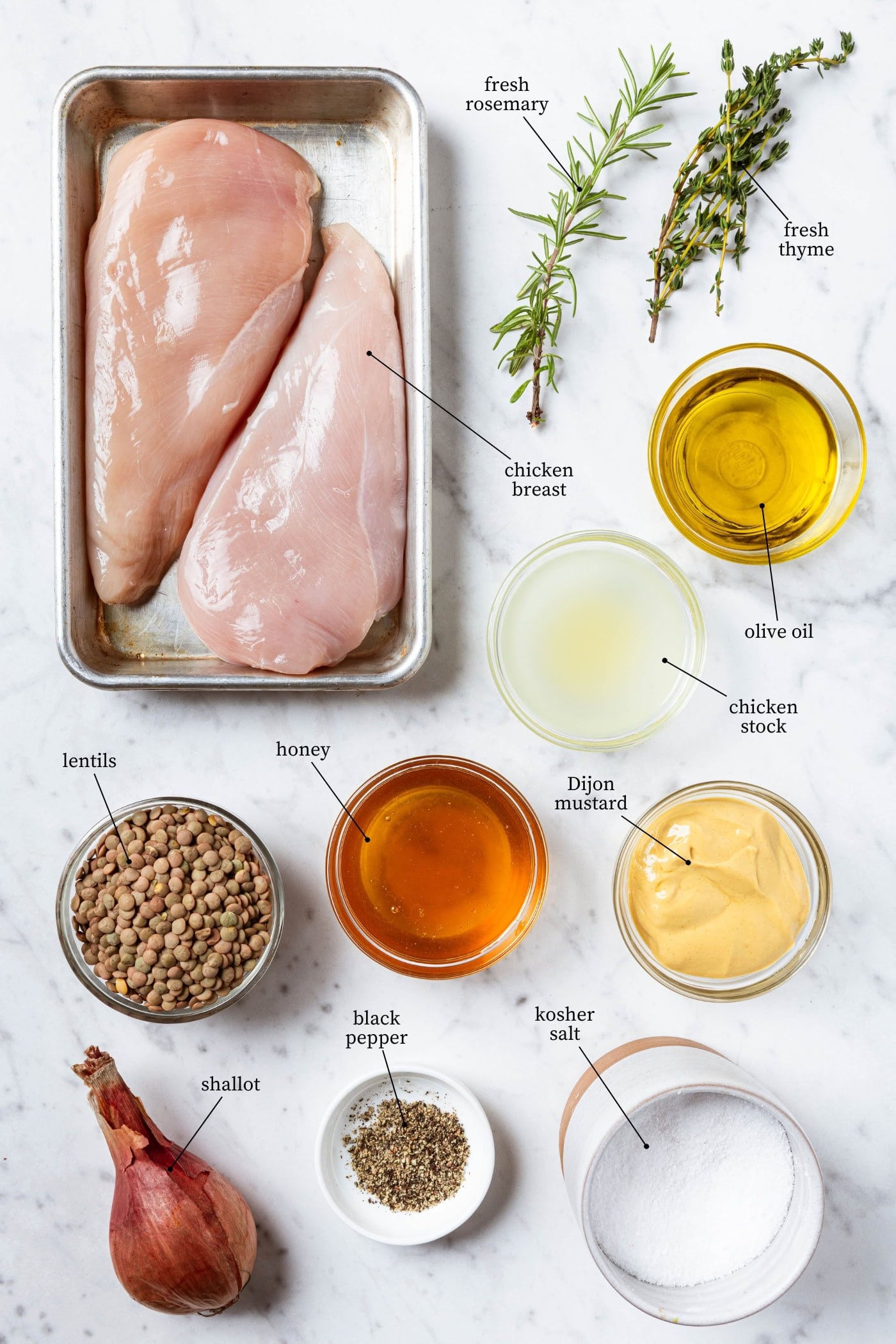 White marble surface filled with ingredients needed for honey mustard chicken recipe.