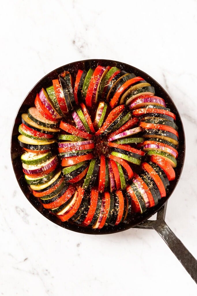 Skillet with slices of vegetables for ratatouille before being baked.