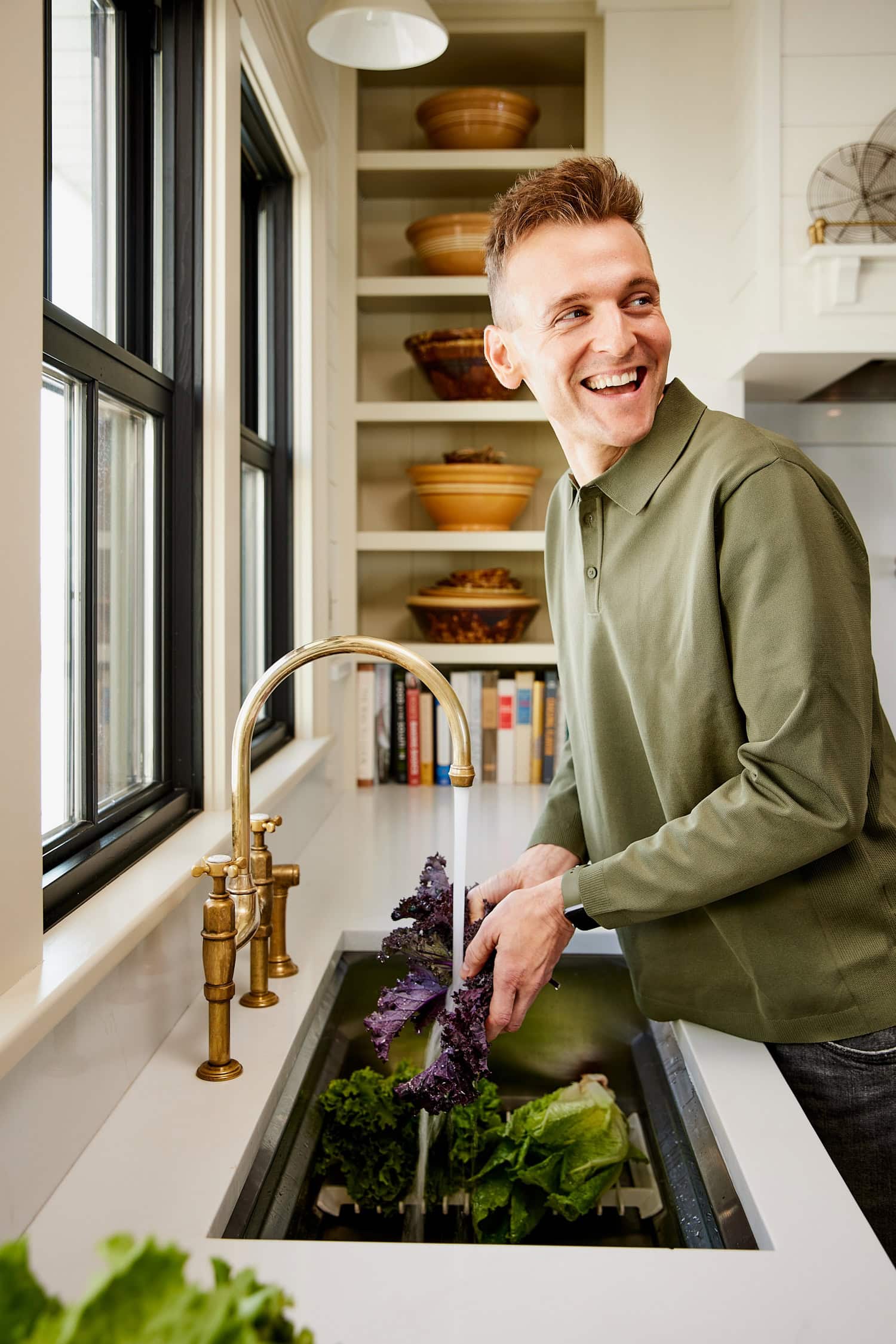 Kaleb Wyse washing lettuce in a sink.
