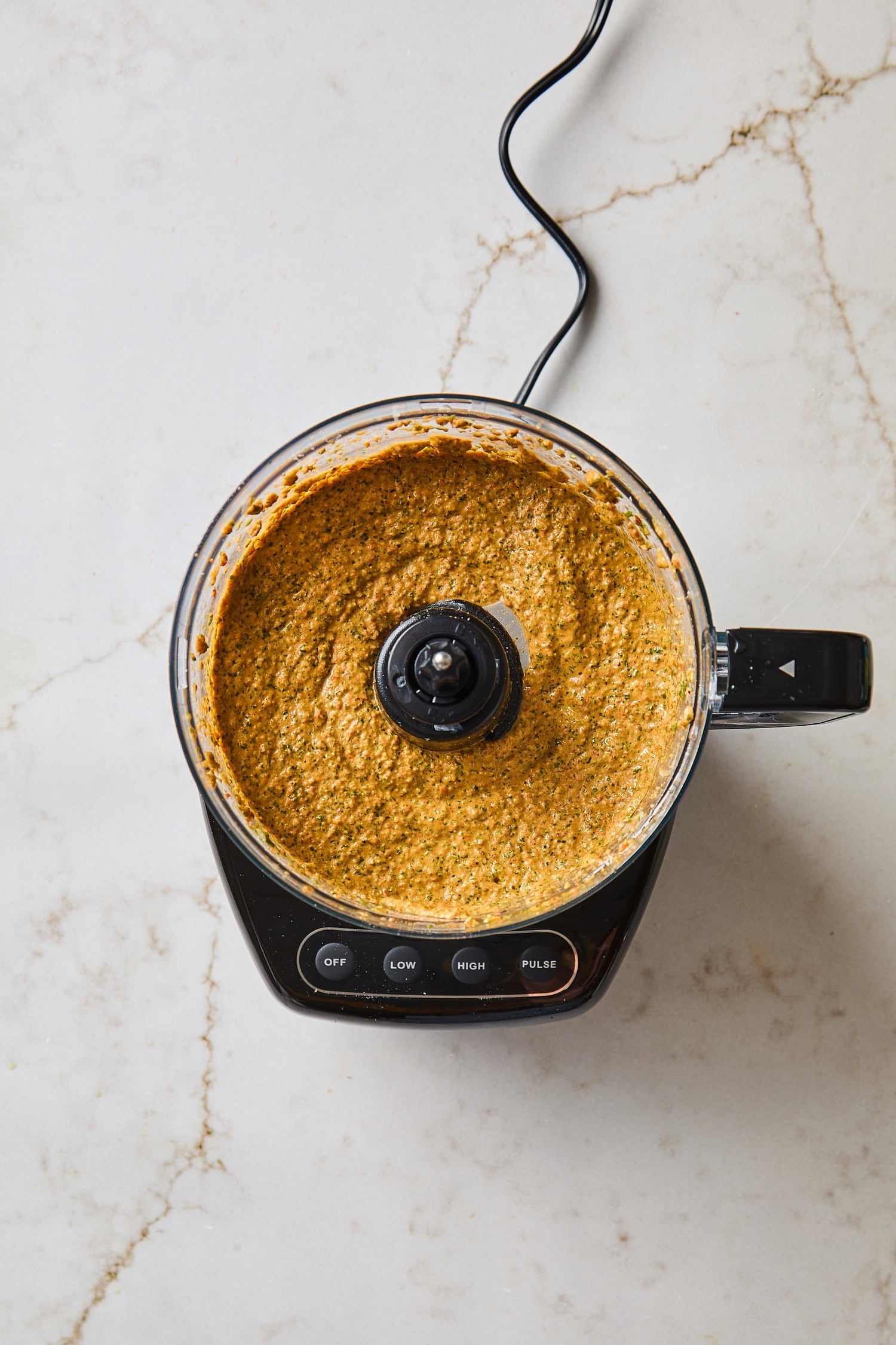 Mixed sauce for arugula pesto in a food processor.