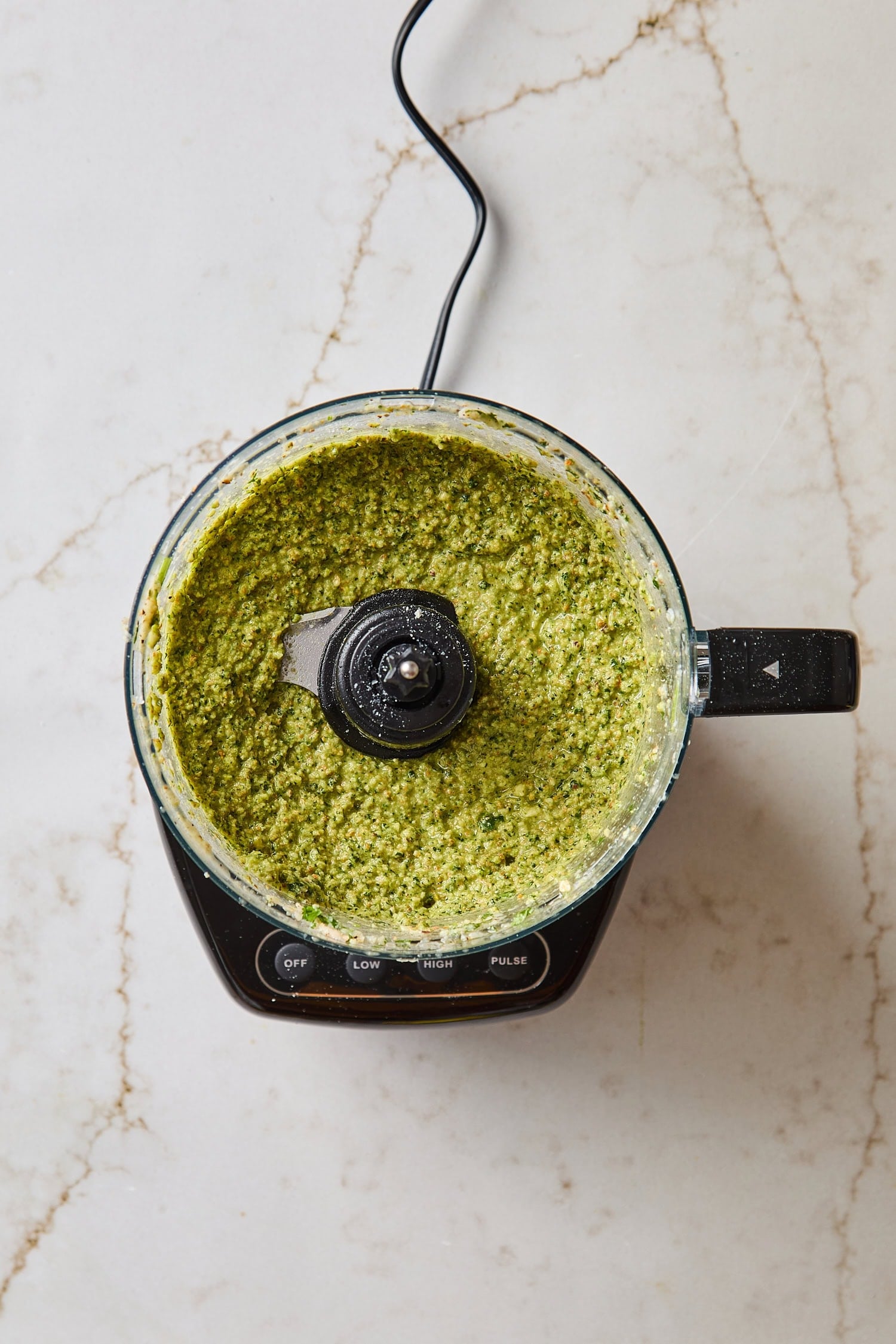 Blended cilantro pesto in a food processor after being mixed.