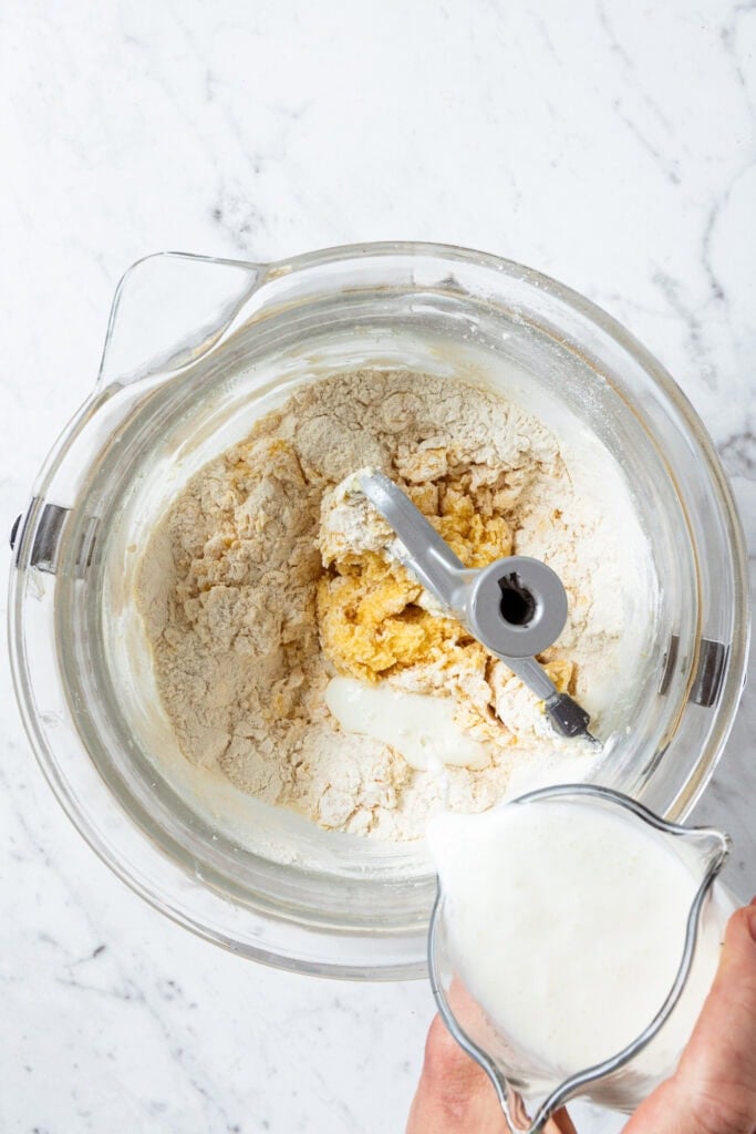 Adding buttermilk to cake batter.
