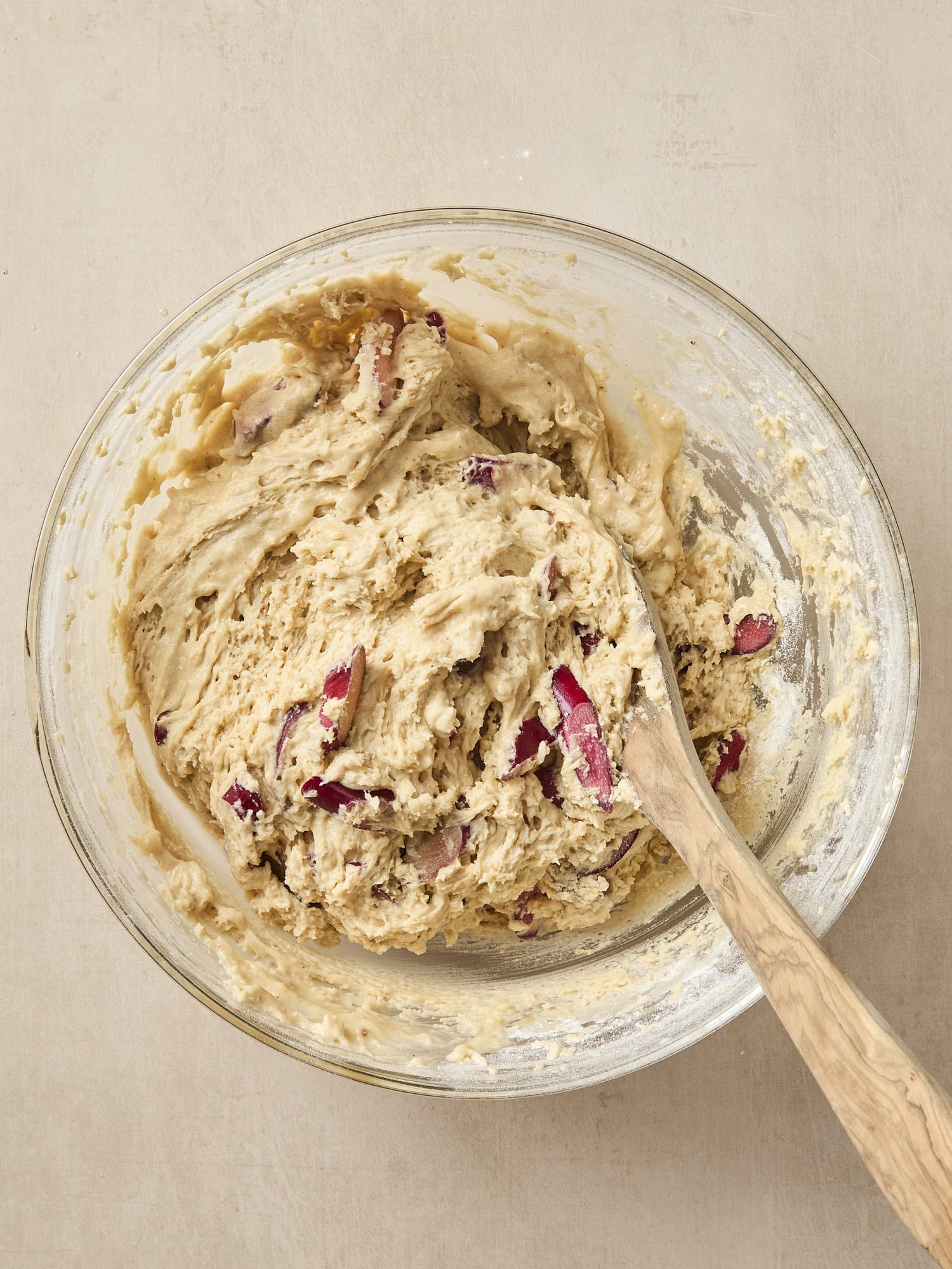 Bowl with batter with pieces of rhubarb stirred in.