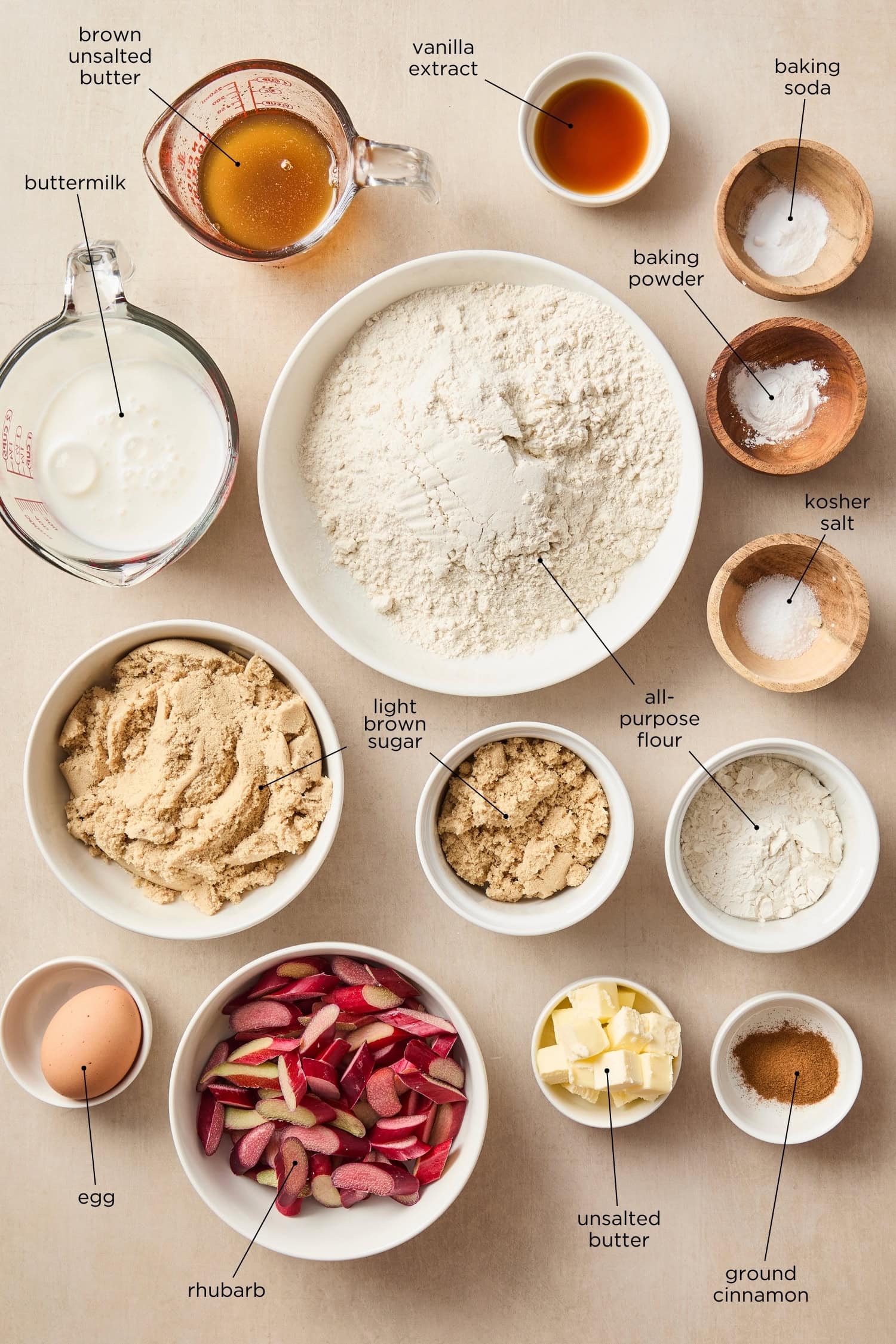 Surface with ingredients for muffins including flour, spices, and rhubarb.