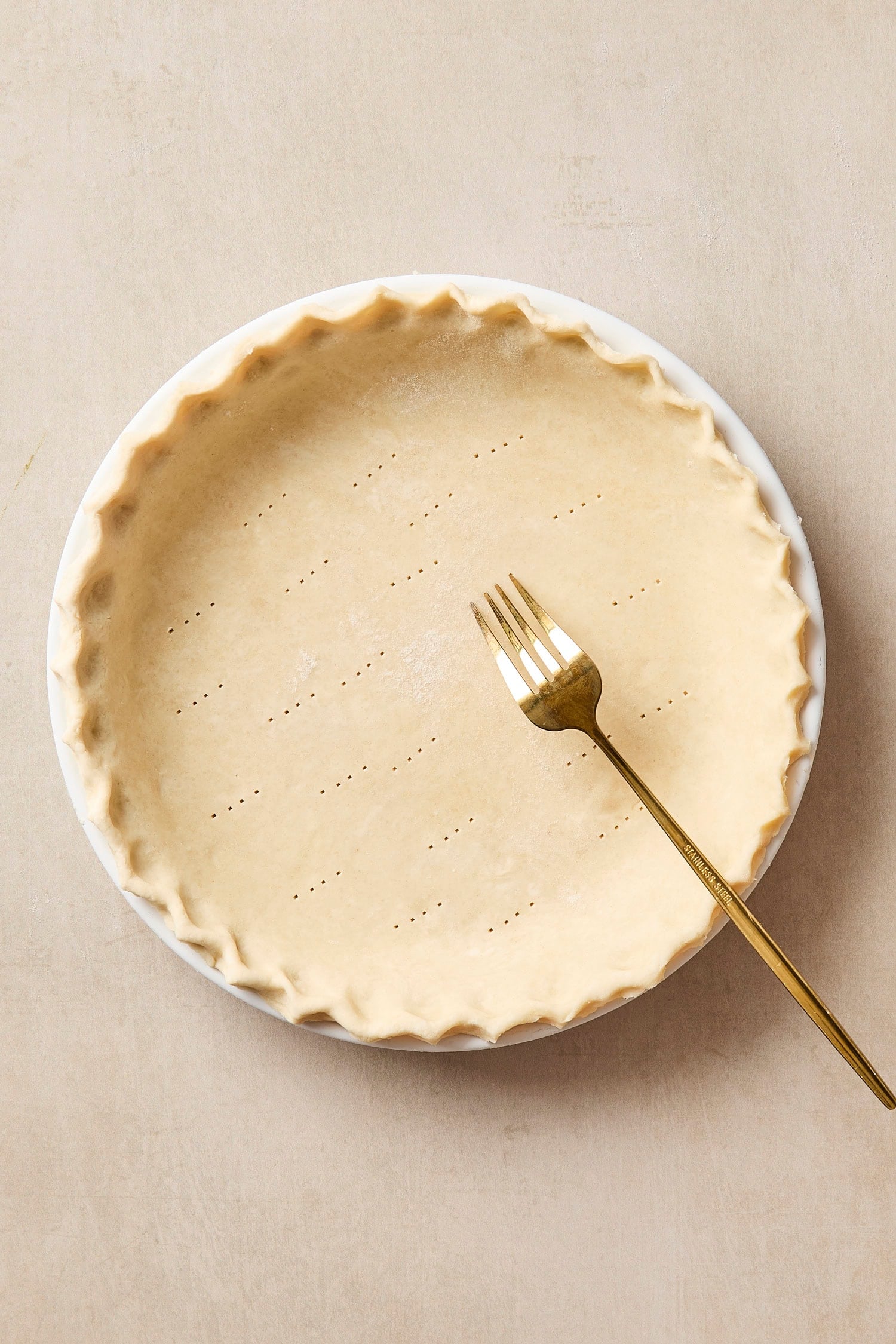 Crust formed in a pie dish to bake a strawberry rhubarb pie,