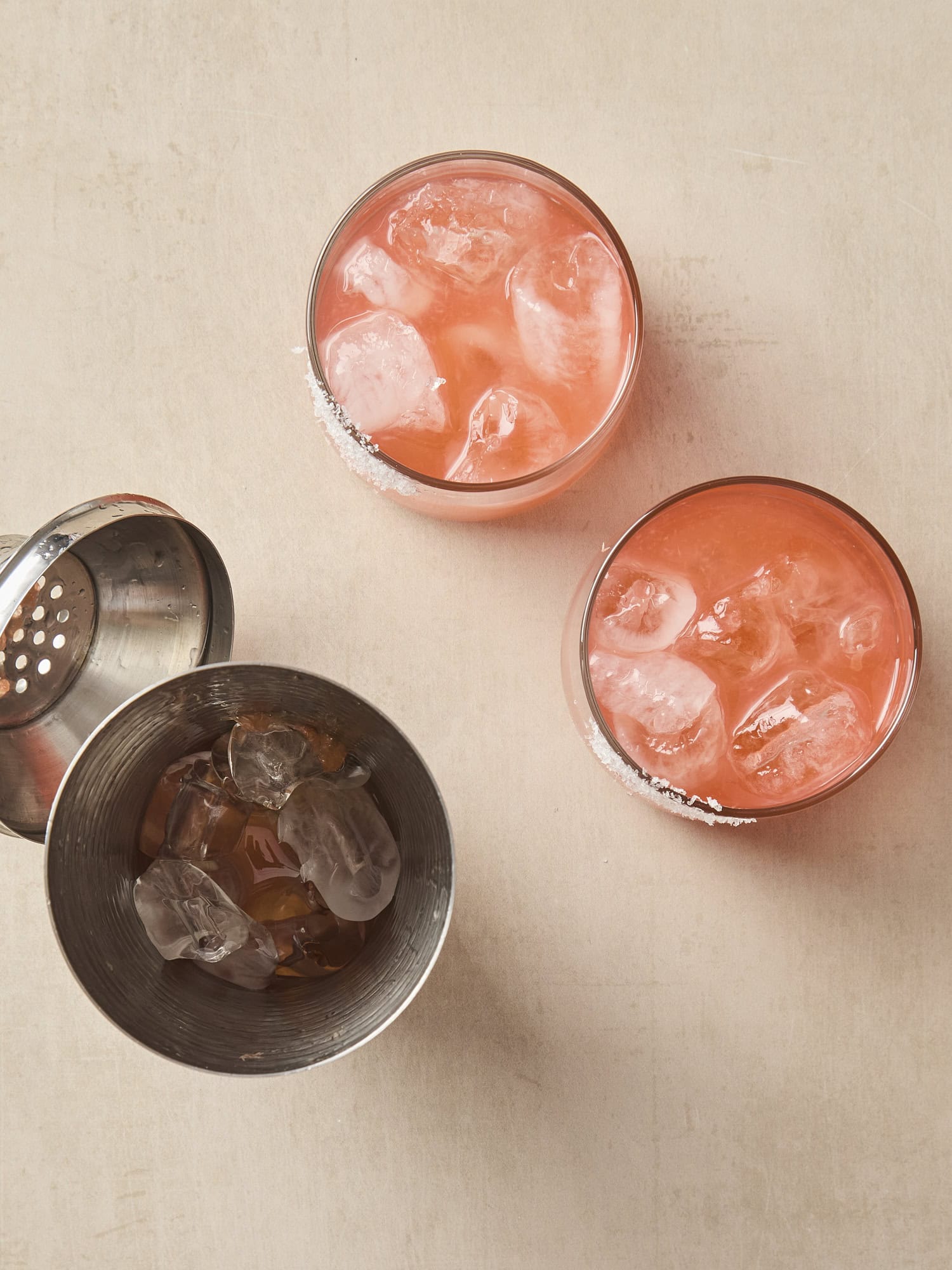 Two glasses filled with siesta cocktail with shaker to the side.