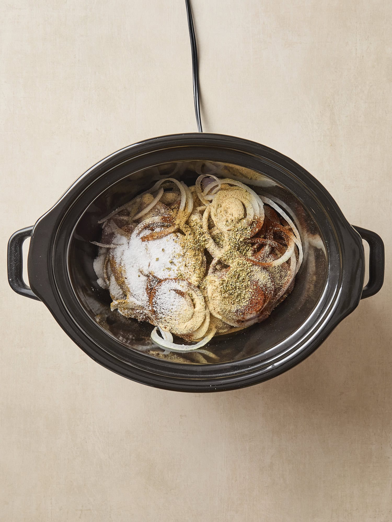 Uncooked ingredients in a slow cooker for chicken tacos meat.