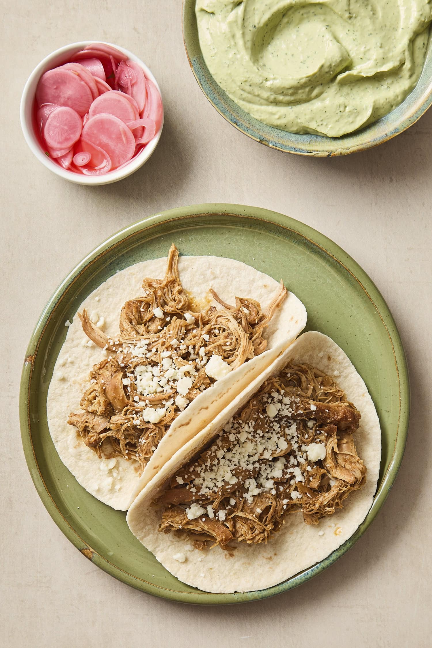 Two slow-cooked chicken tacos on a plate.