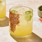 Glass filled with spicy margarita with seasoning on glass as garnish.