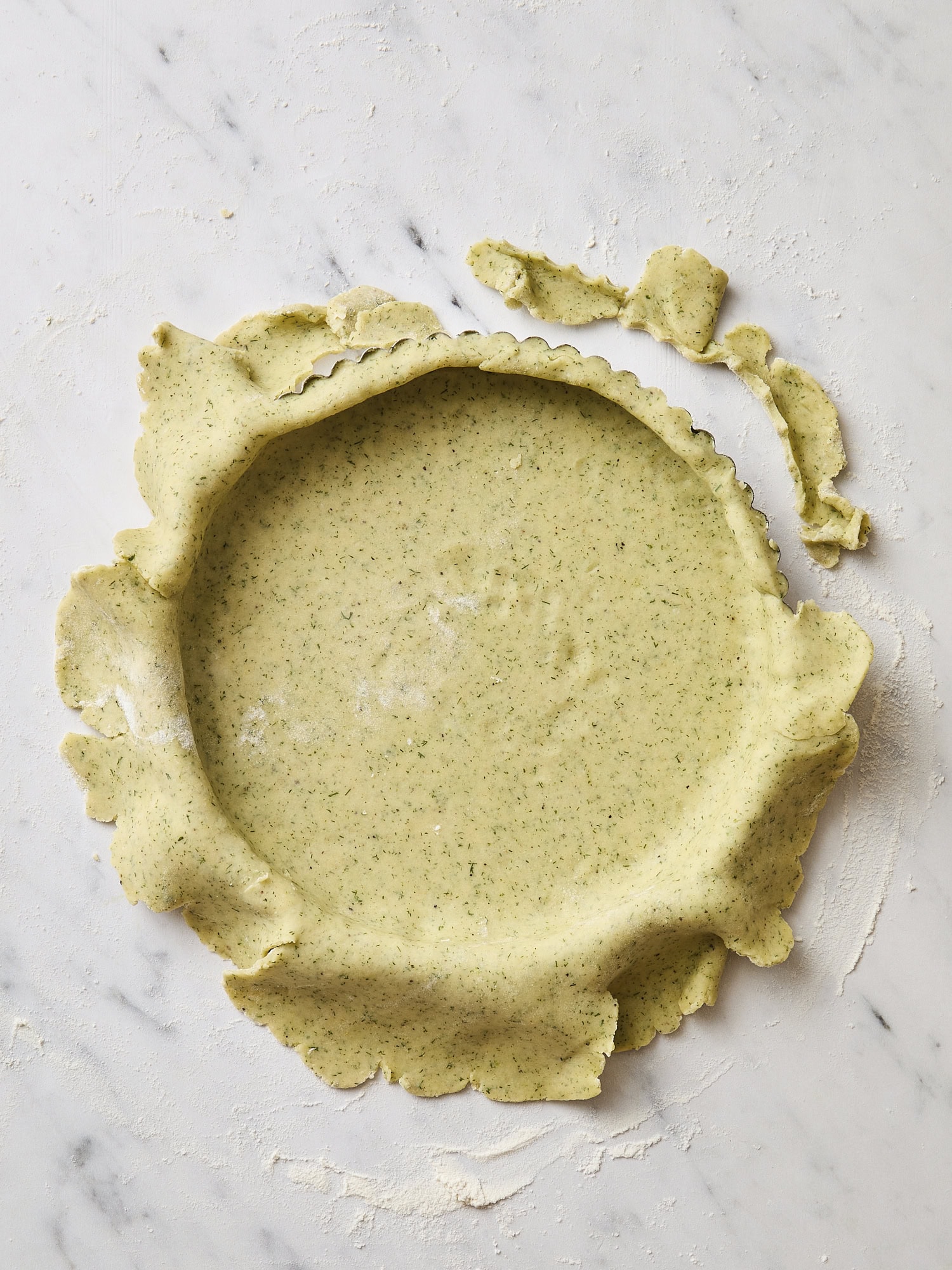 Lightly green colored dough pressed into a tin pan for a crust.