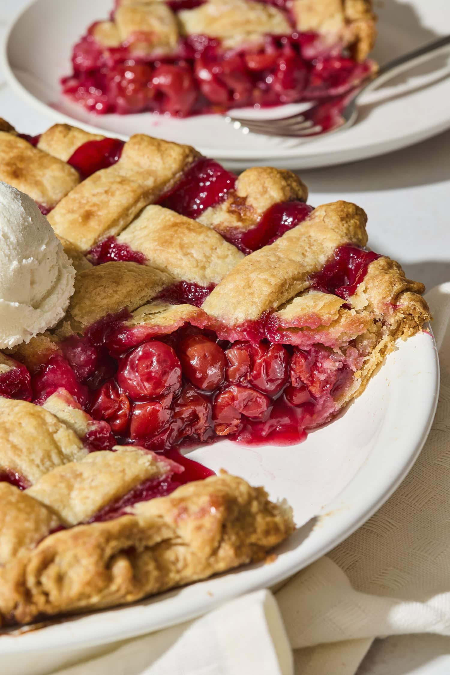 Cherry pie with slice removed with bright red cherries in the crust.