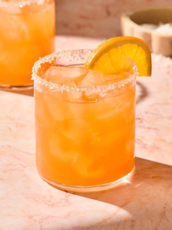 Orange colored Italian margarita in a glass with an orange slice.