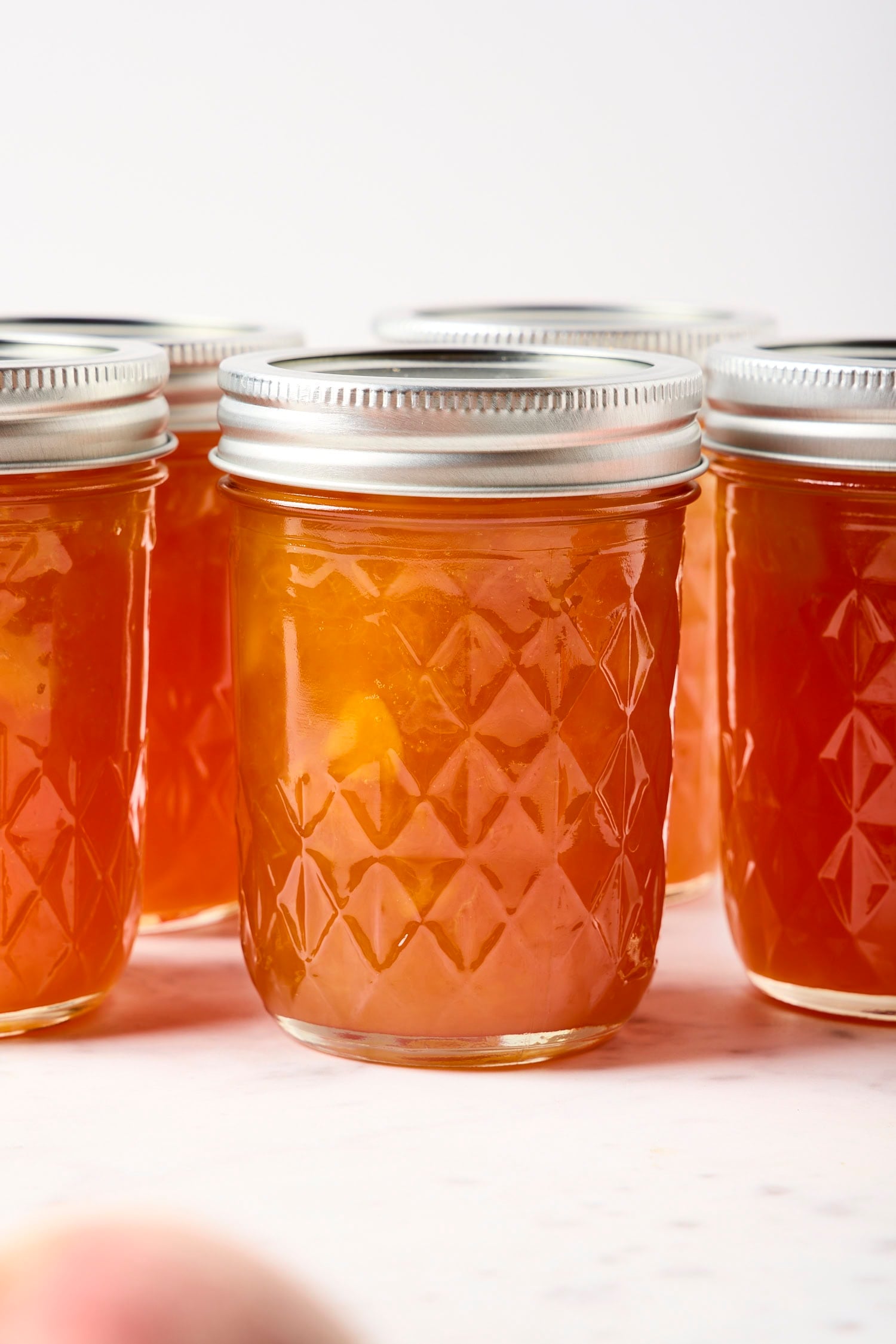 Peach jam in a glass jar.