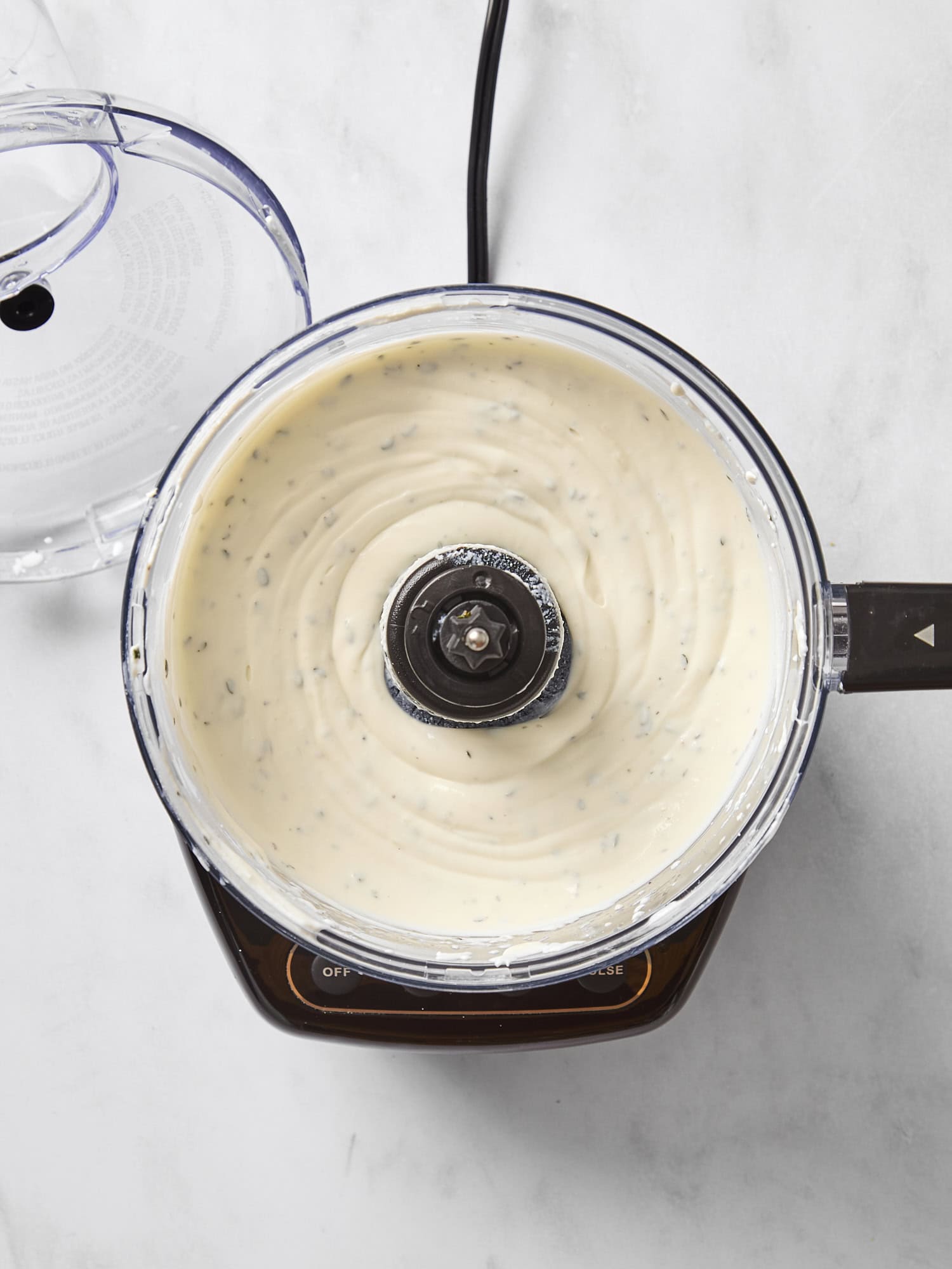 Food processor with ricotta dip whipped up inside.