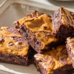 A platter with pumpkin cheesecake brownies topped with flaky salt.