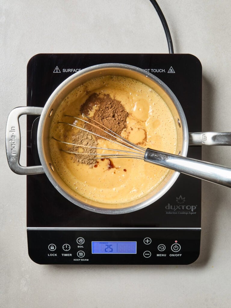 Flavorings being added to a pumpkin ice cream mixture.